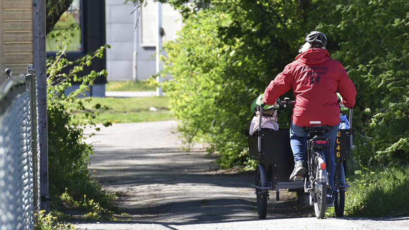 förskollärare som cyklar på en förskolecykel med barn i 