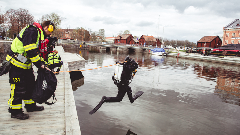 En dykare som hoppar i vattnet från en kaj